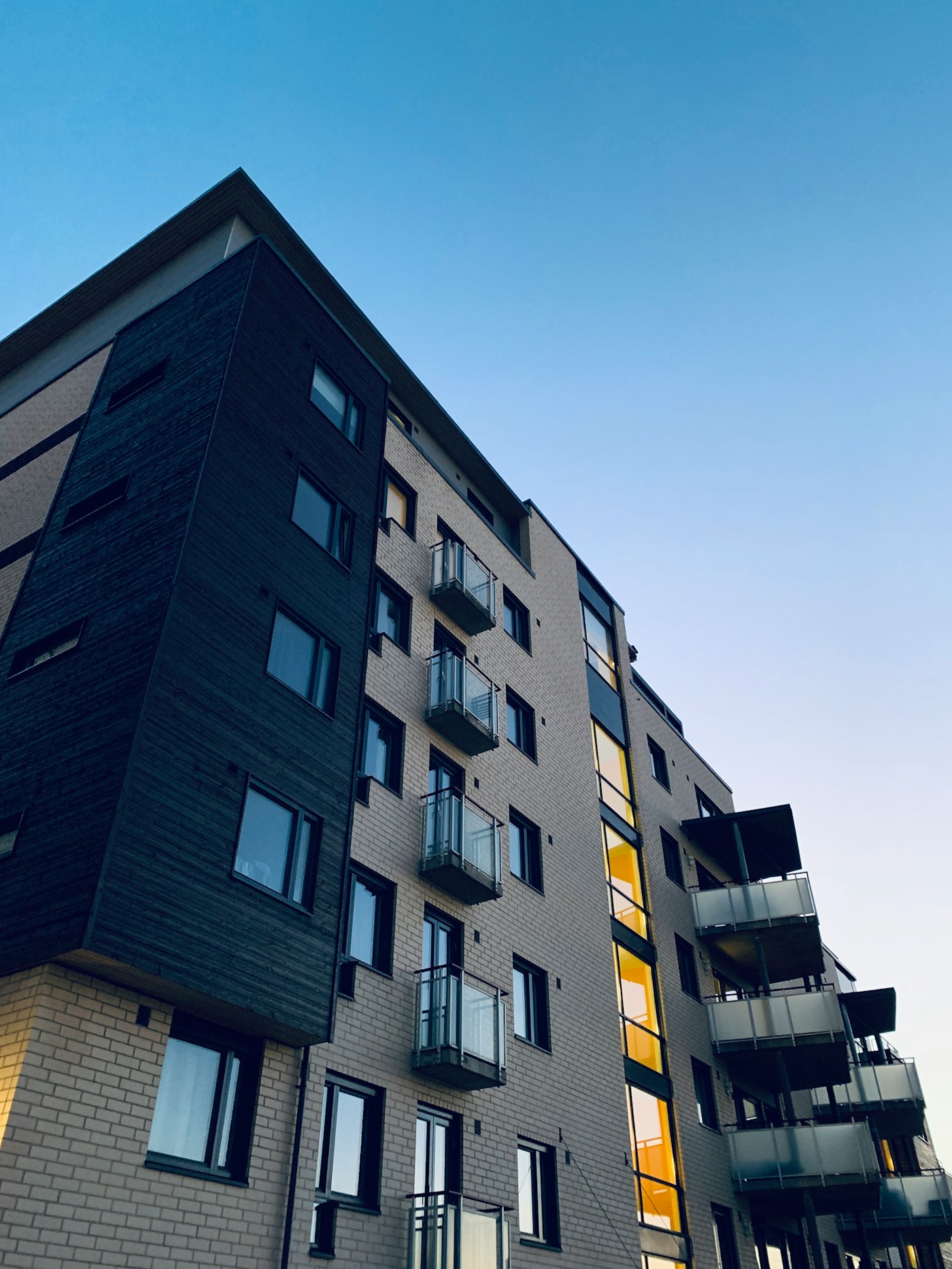 Modern residential building with lit balconies at dusk
